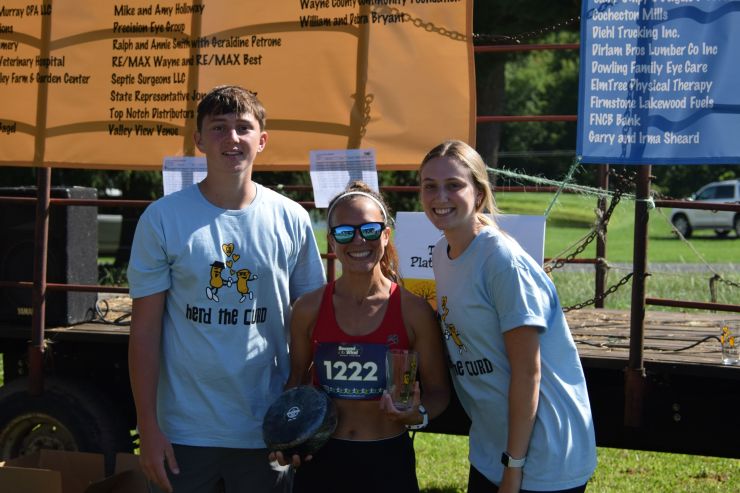 Jennifer Nolan, the 2023 Women’s 10K Winner with Mollie Bomgardner and Rylan Montgomery, Herd the Curd family members. 